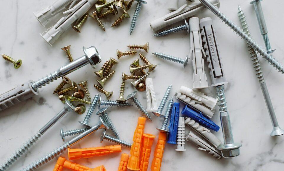 Bunch of various multicolored dowels and screws on white table
